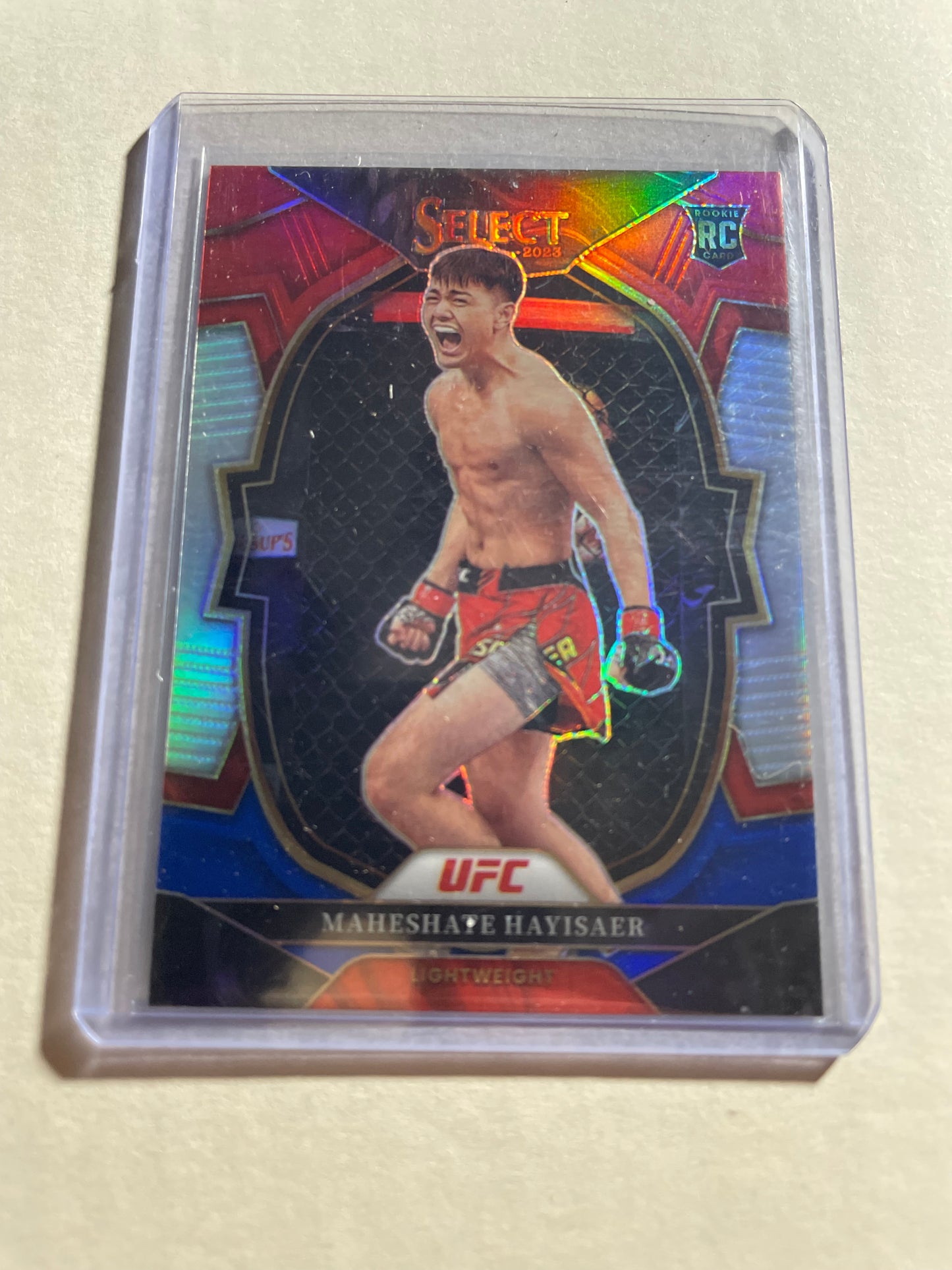 2023 Panini Select UFC Concourse Red & Blue Prizm rookie card (#49) features fighter Maheshate Hayisaer.