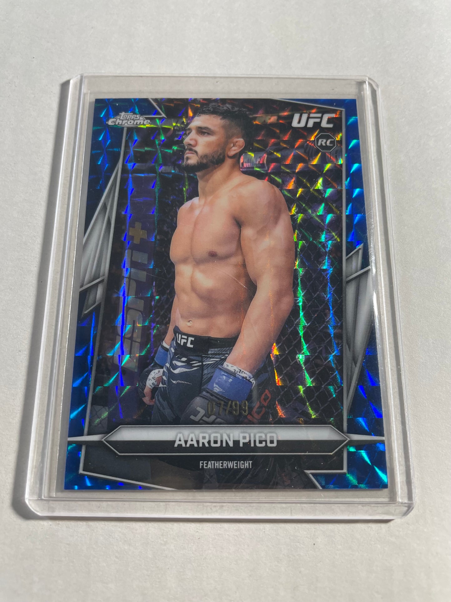 2026 Topps Chrome UFC Aaron Pico Rookie Card, specifically featuring a blue geometric refractor parallel.The card is numbered 007/99, indicating it is a limited edition parallel.